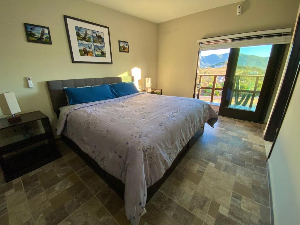 um quarto com uma cama e uma grande janela em Finca de Lulu y Jose Ruta del Vino em Valle de Guadalupe