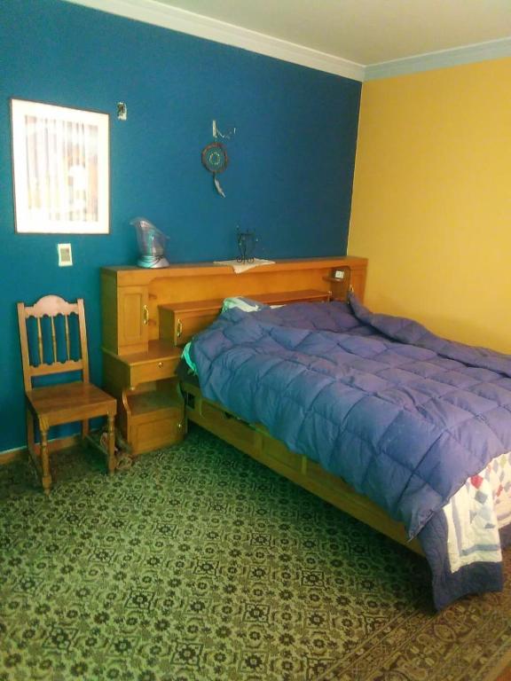 a bedroom with a bed and a desk and a chair at Casa Ballesteros Rodríguez in Oruro