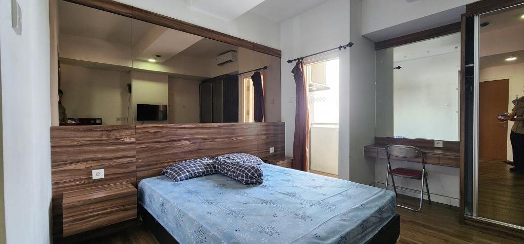 a bedroom with a bed and a large mirror at Apartemen Menara One Surakarta by Cariapartemen-id in Sukoharjo