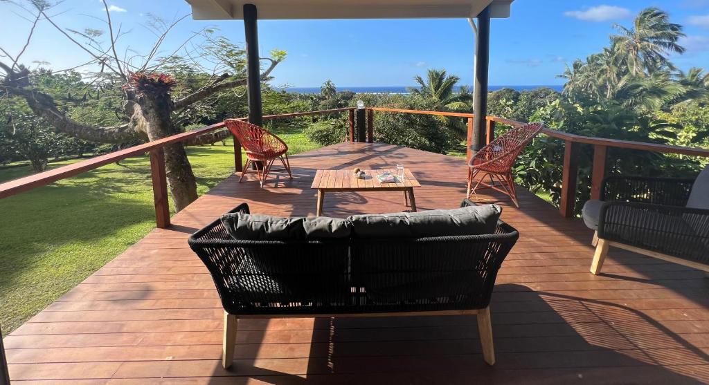 une terrasse en bois avec une table et des chaises. dans l'établissement Avocado Retreat, à Rarotonga