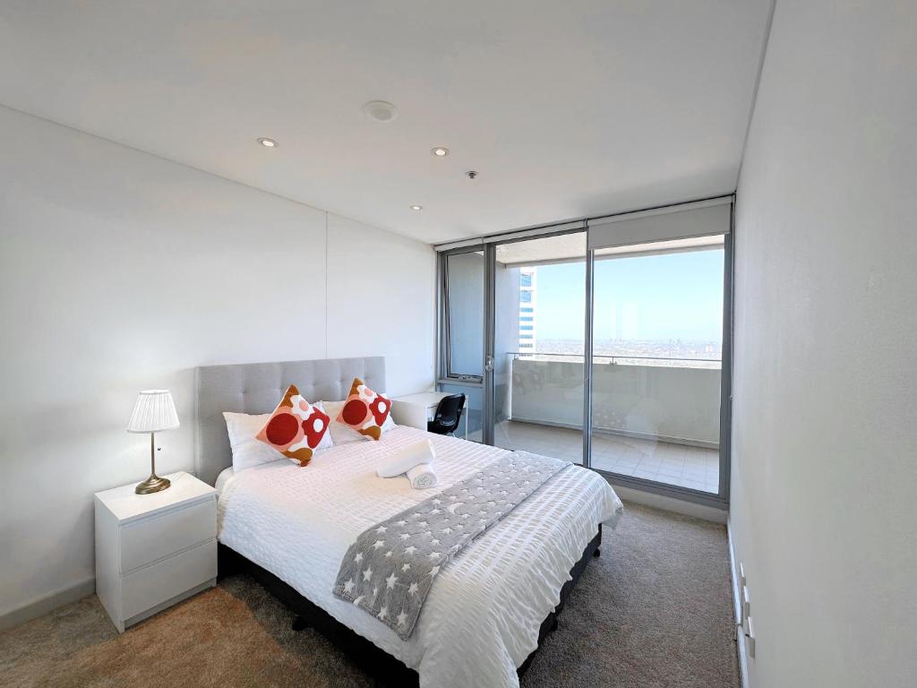 a white bedroom with a bed and a large window at Share House Master Room Near Chatswood Station in Sydney