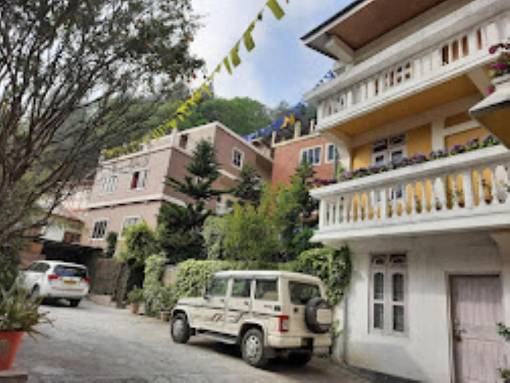 a white jeep parked in front of a building at Hotel Keeduk Inn Dirang in Dirang Dzong