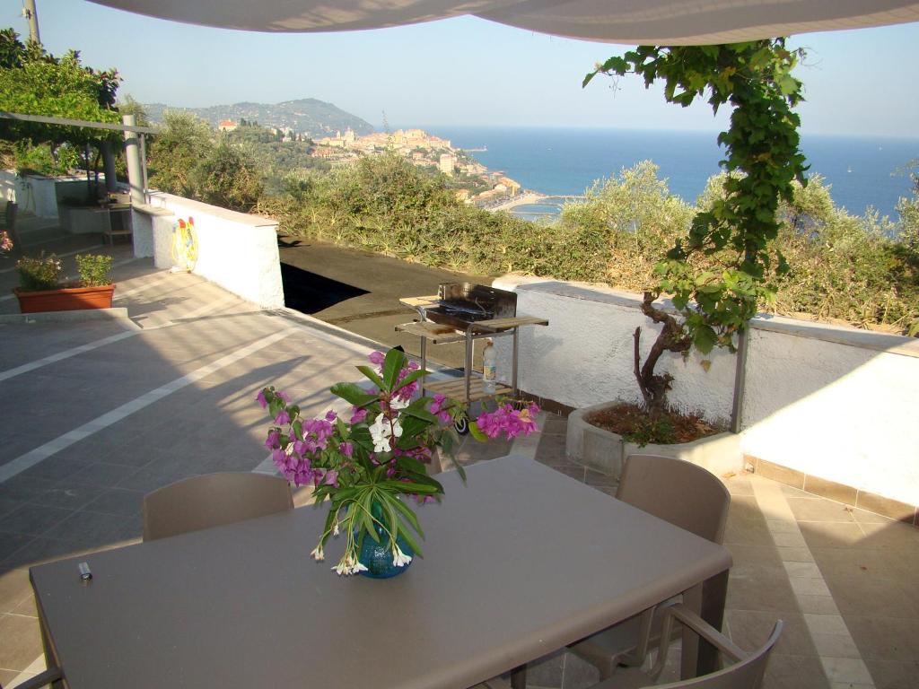 een witte tafel met bloemen op het balkon bij Le Dimore di Chiara in Imperia