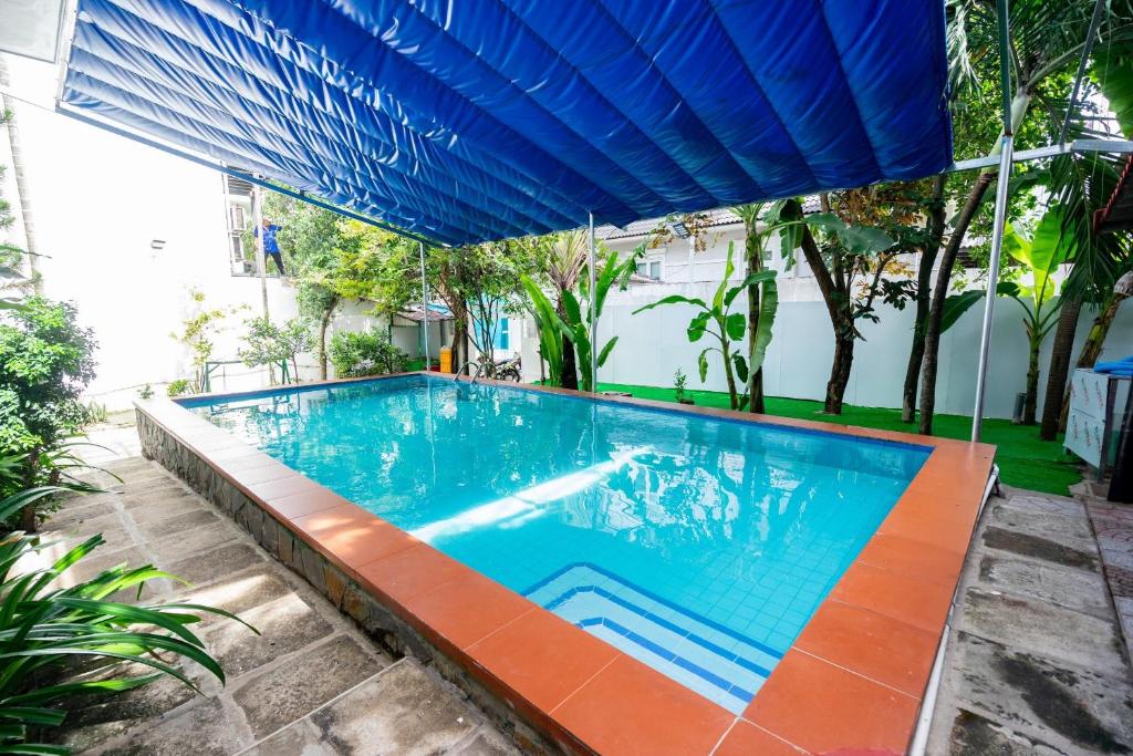 una gran piscina bajo una sombrilla azul en Gem villa 1915-16 phòng ngủ-2 hồ bơi lớn en Ho Chi Minh