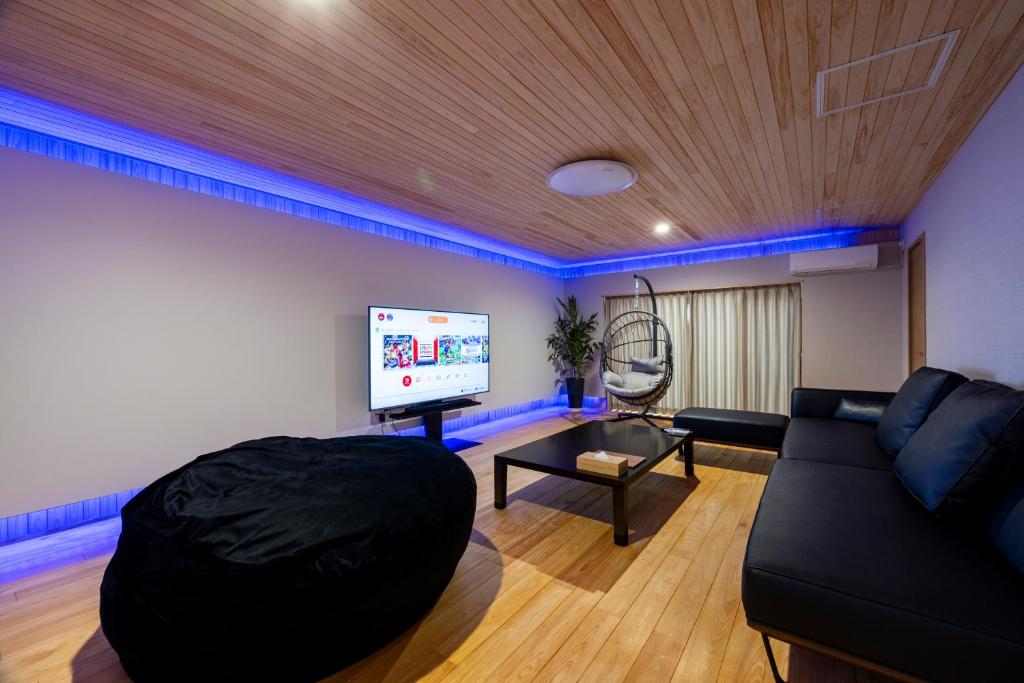Hinoki house في فوكوكا: غرفة معيشة مع أريكة وتلفزيون بشاشة مسطحة