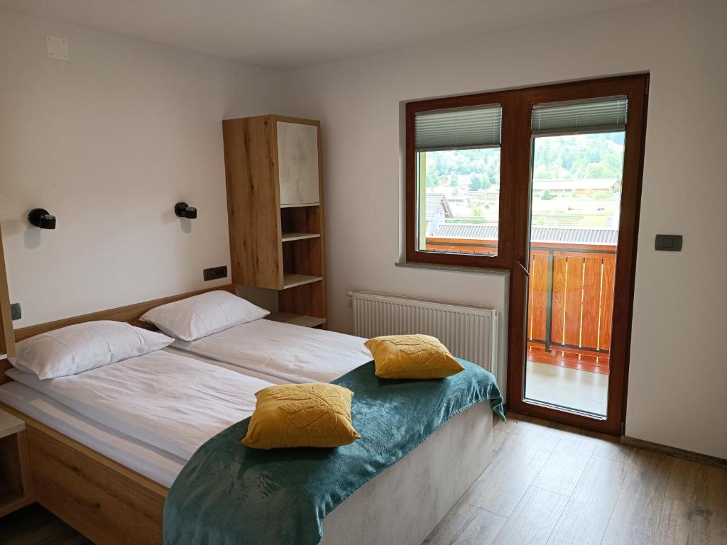 1 dormitorio con 1 cama con 2 almohadas amarillas en Apartmaji Hodak, en Bohinj