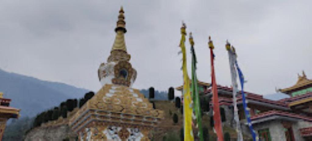 a building with a tower on top of it with flags at Hotel Dirang Buddha Dirang in Dirang Dzong