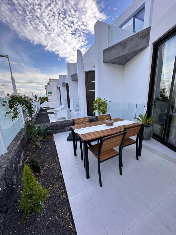 une terrasse avec une table en bois et des bancs dans un bâtiment dans l'établissement Papá Totë Deluxe, à Playa Honda