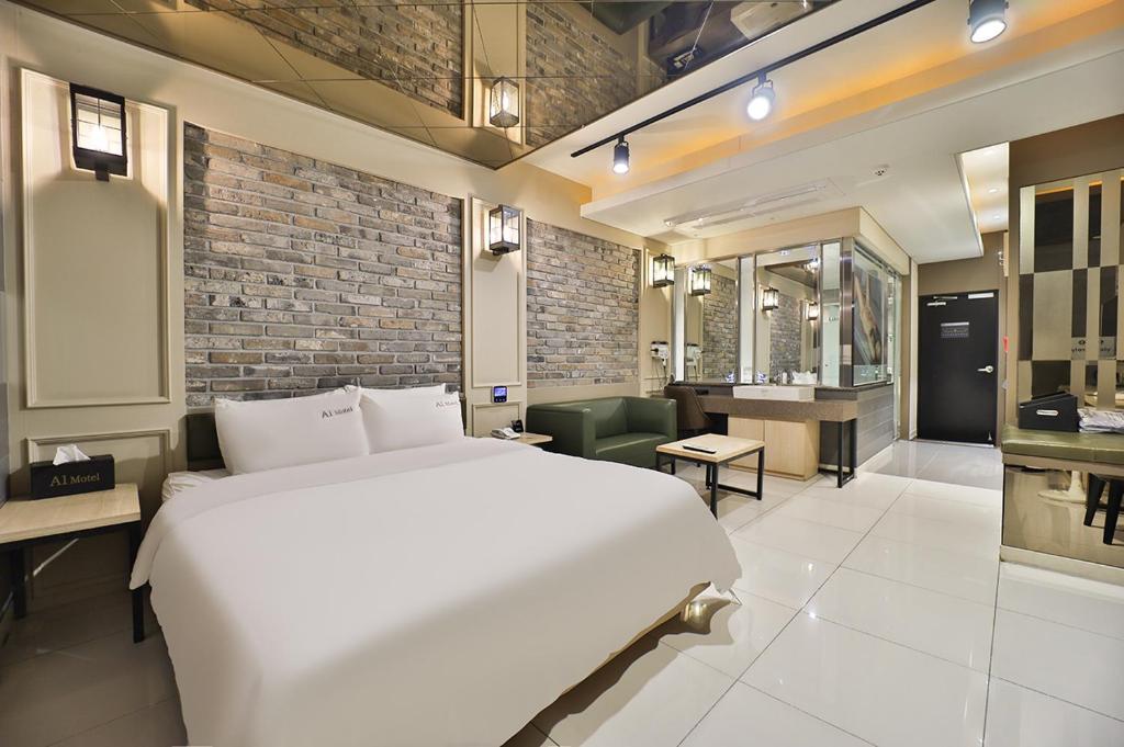 1 Schlafzimmer mit einem großen weißen Bett und einem Badezimmer in der Unterkunft Pohang A1 Jukdo in Pohang