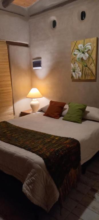 a bedroom with a large bed with green and brown pillows at La adorable in Los Reartes