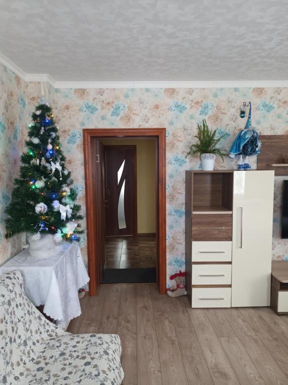 een woonkamer met een kerstboom in een kamer bij Dzīvoklis Tukuma centrā in Tukums