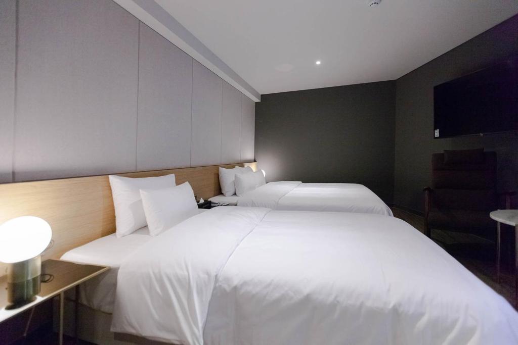 Postel nebo postele na pokoji v ubytování Brown Dot Hotel Hadan