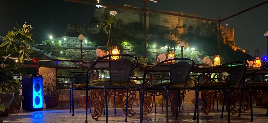 a group of chairs sitting at a table at night at Shahi Guest House in Jodhpur