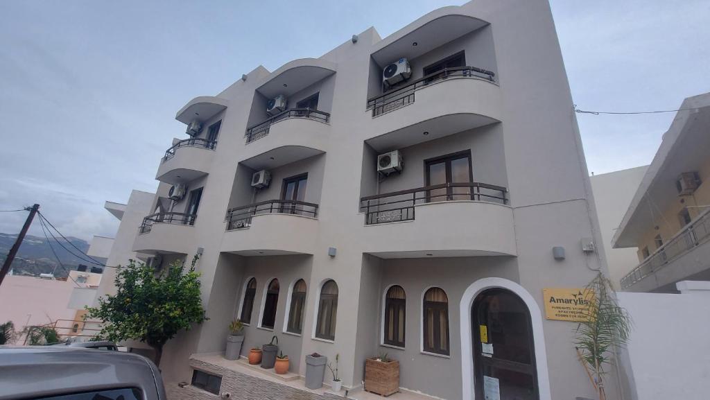 een wit gebouw met balkons aan de zijkant bij Amaryllis Hotel in Karpathos