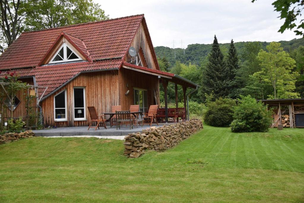Cabaña de madera con mesa y sillas en el patio en Ferienhaus SonnenFänger, en Hemfurth-Edersee