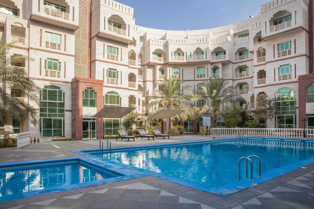 a swimming pool in front of a building at Muscat Oasis Residences in Muscat