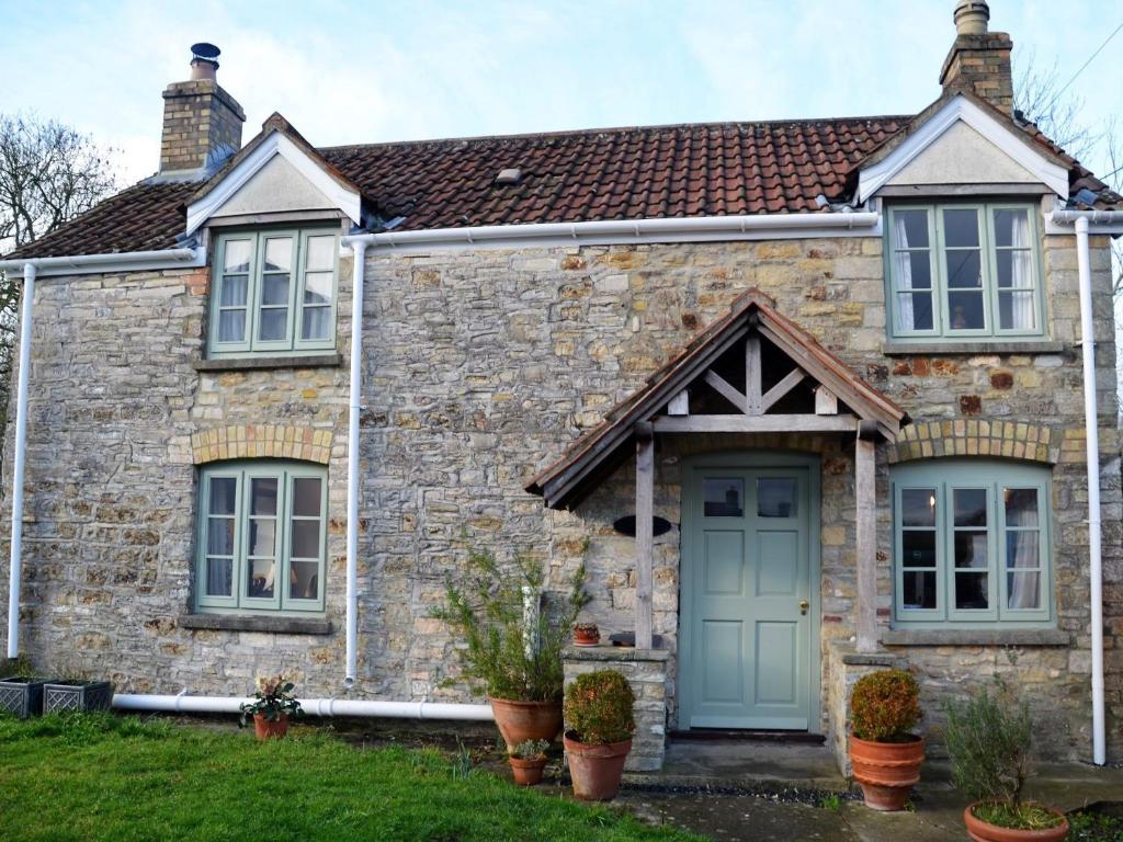 a stone house with a blue door at 2 Bed in Wedmore 53989 in Wedmore