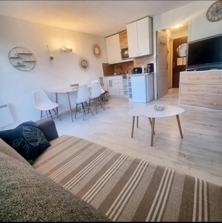 a kitchen and a living room with a table and a couch at 100 m de la plage - Les Cigales de Mer - Studio Cabine - Parking in Le Grau-du-Roi