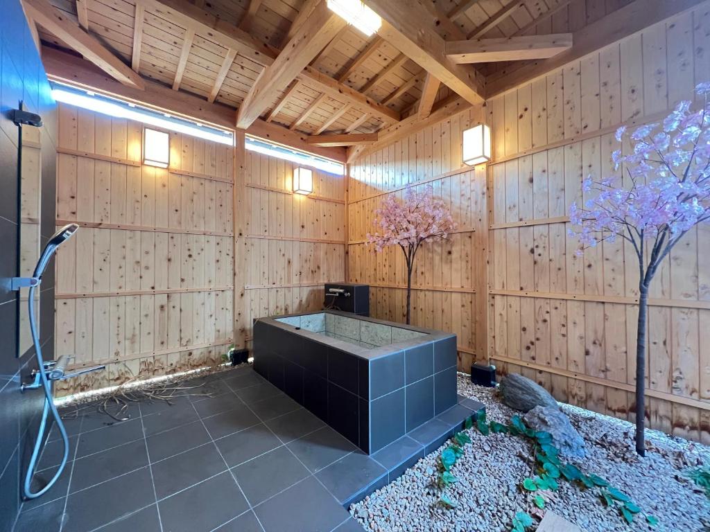 een badkamer met een douche in een houten muur bij ～Fushimi Inari～露天風呂付の一棟貸切のゲストハウス in Kyoto