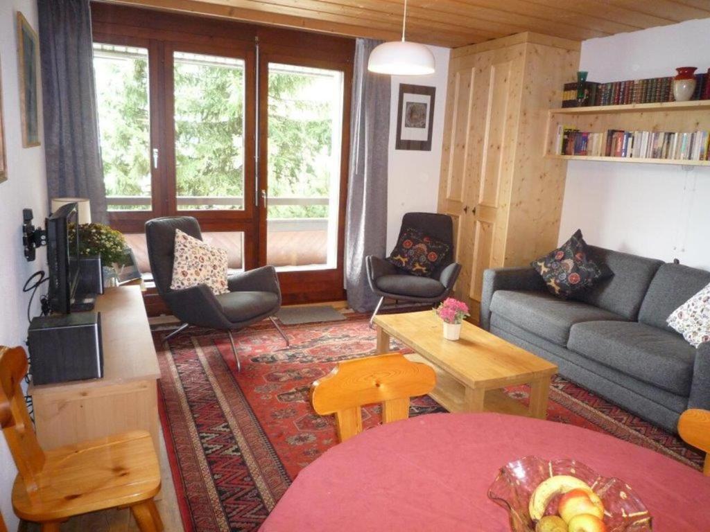 ein Wohnzimmer mit einem Sofa, Stühlen und einem Tisch in der Unterkunft Des Alpes in Davos