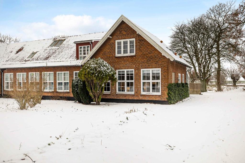 a brick house with snow on the ground at Stately Apartment Incl, Consumption in Bogense