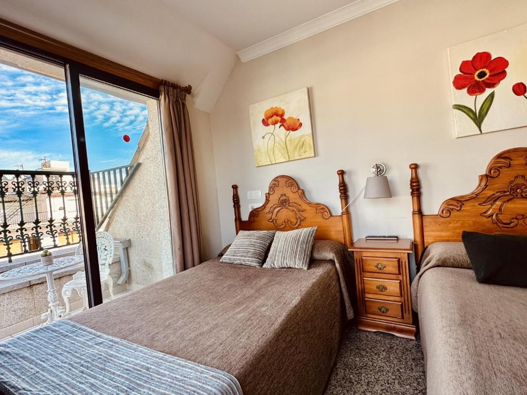 a bedroom with two beds and a balcony at Hotel Reyesol in Fuengirola