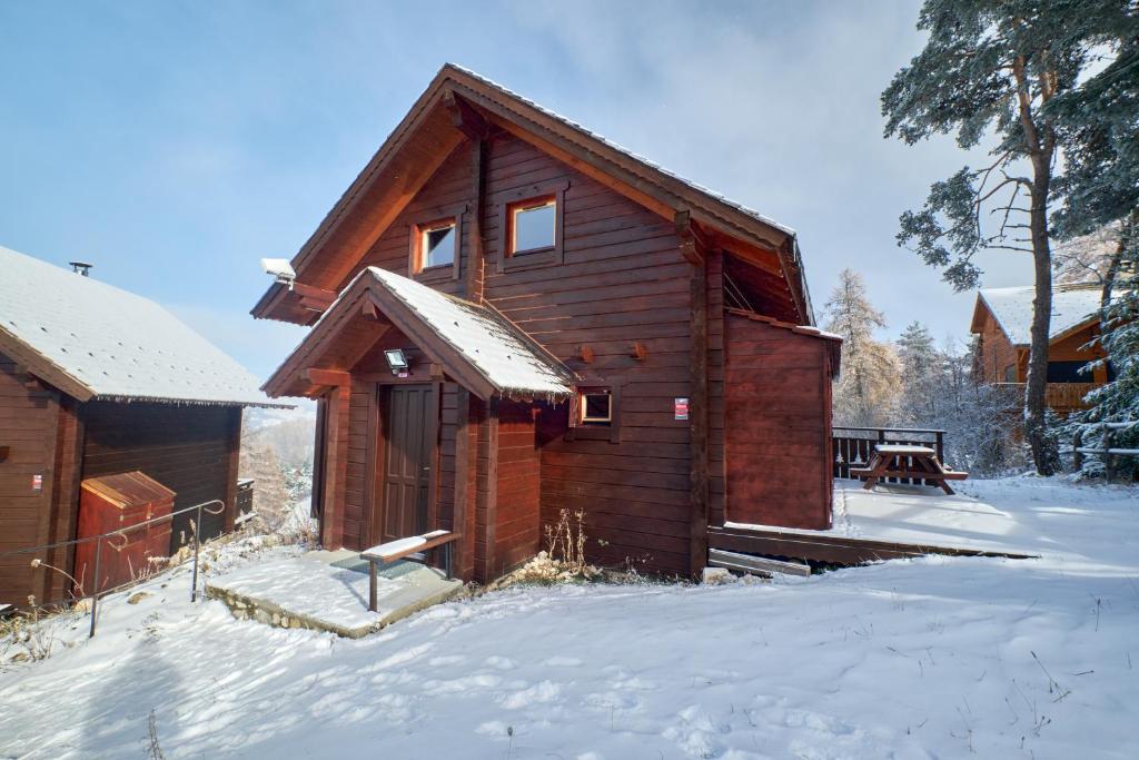 een kleine houten hut met sneeuw op de grond bij Le chalet Virginie in Le Dévoluy