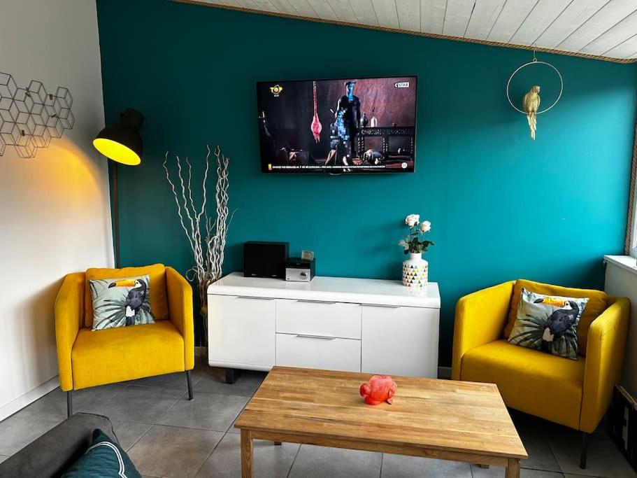 un salon avec deux chaises jaunes et une table dans l'établissement Lodge des pins au coeur de la forêt d'Olonne, à Olonne-sur-Mer