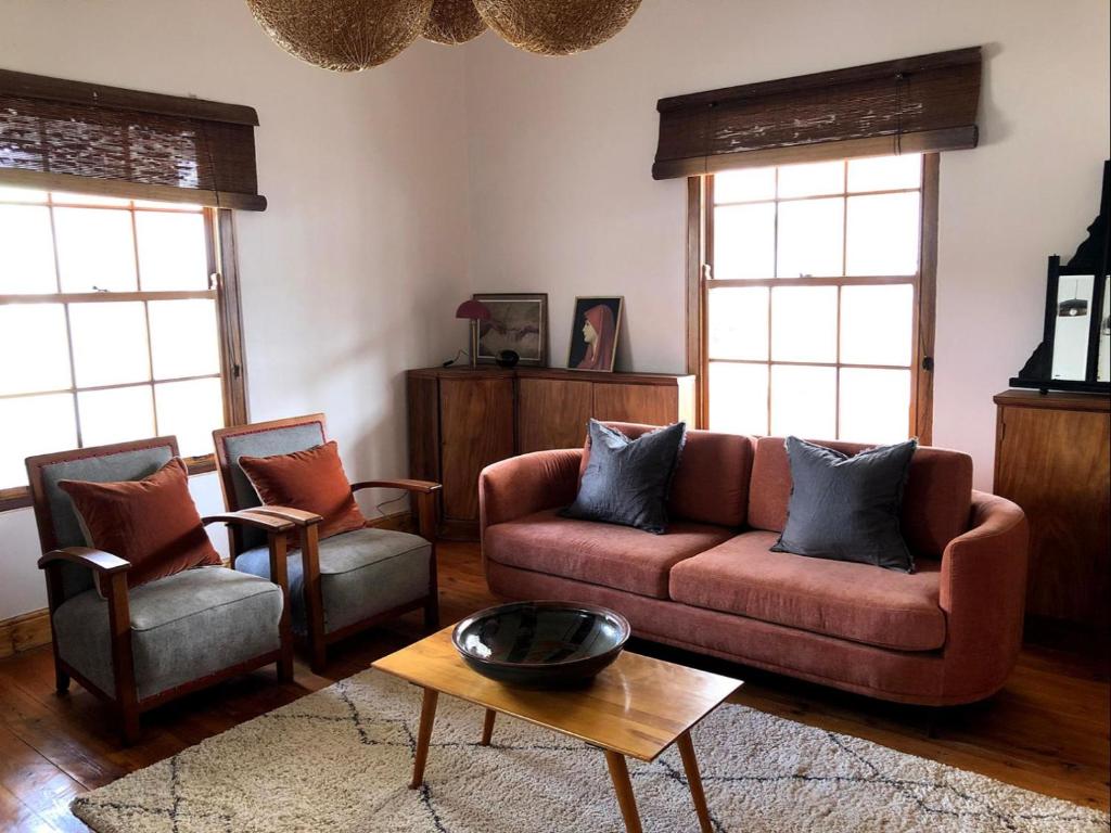 ein Wohnzimmer mit einem Sofa und 2 Stühlen in der Unterkunft The Dusty Vine in Philippolis