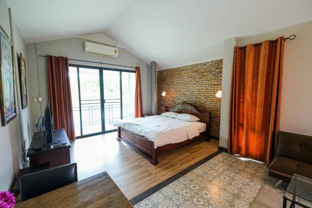 um quarto com uma cama e uma parede de tijolos em Busaya Resort & Cuisine em Nakhon Pathom