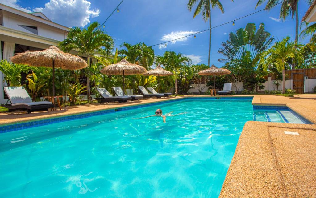 a person swimming in a swimming pool at Dolce Amore Resort in Siquijor