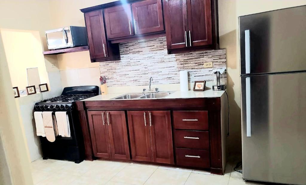 a kitchen with a sink and a stainless steel refrigerator at 3bedrm, 2 bthrm. 7East Greater Portmore in Portmore