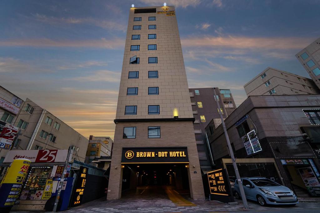 um edifício alto no meio de uma cidade em Brown Dot Hotel Hadan em Busan