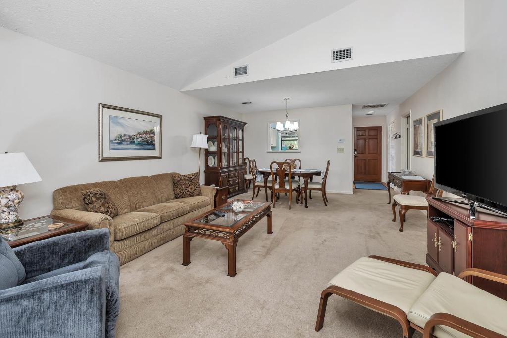 a living room with a couch and a tv at Harbour Oaks 604 in Saint Simons Island