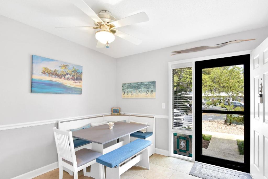 comedor con mesa y sillas y ventilador de techo en Turtle Cove en Saint Simons Island