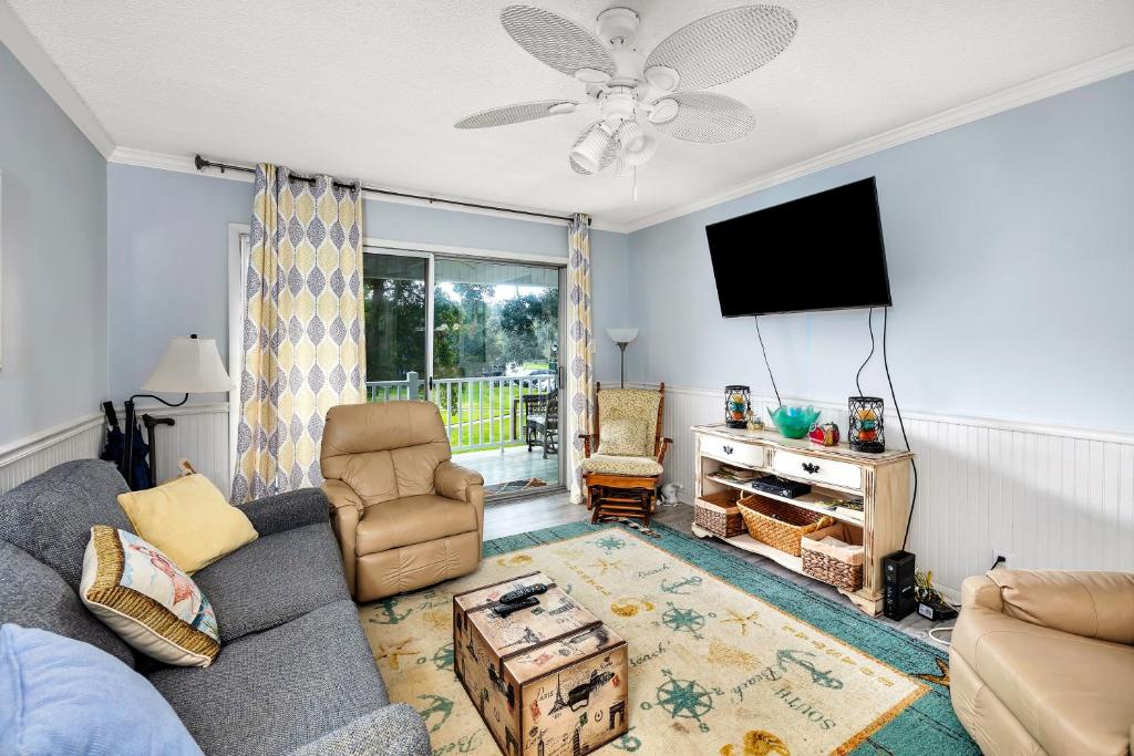 a living room with a couch and a flat screen tv at Ocean Walk H-14 in Saint Simons Island