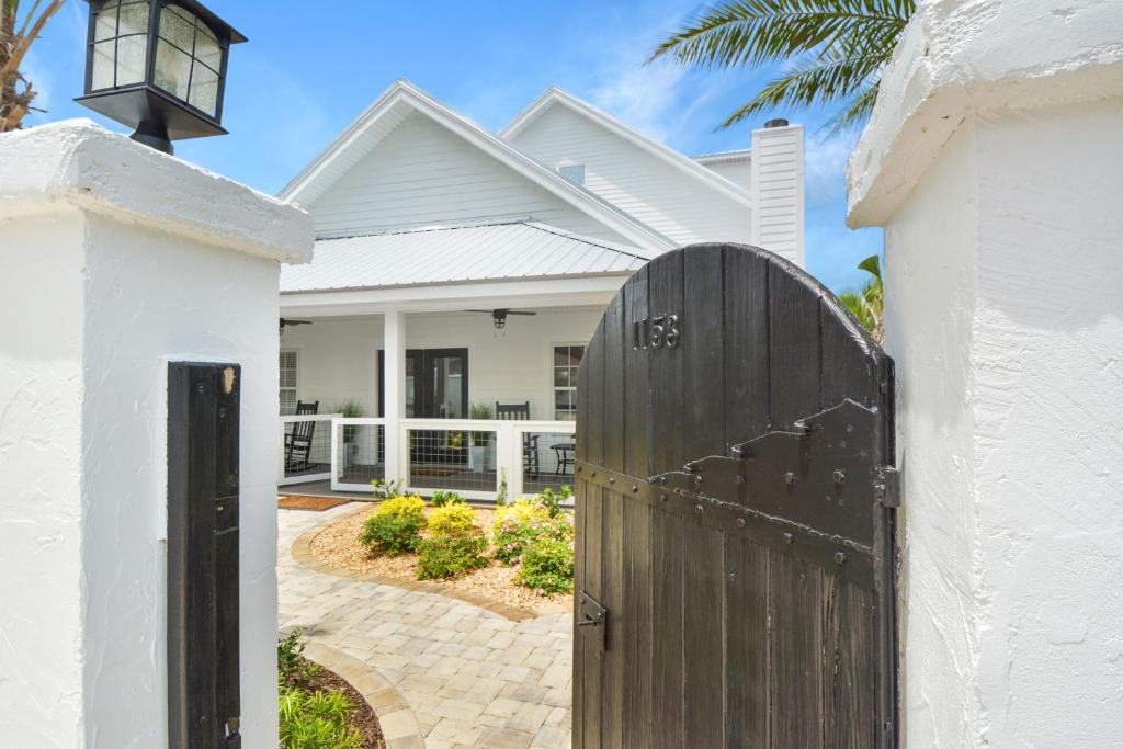 a white house with a wooden gate at Island Attitude in Saint Simons Island