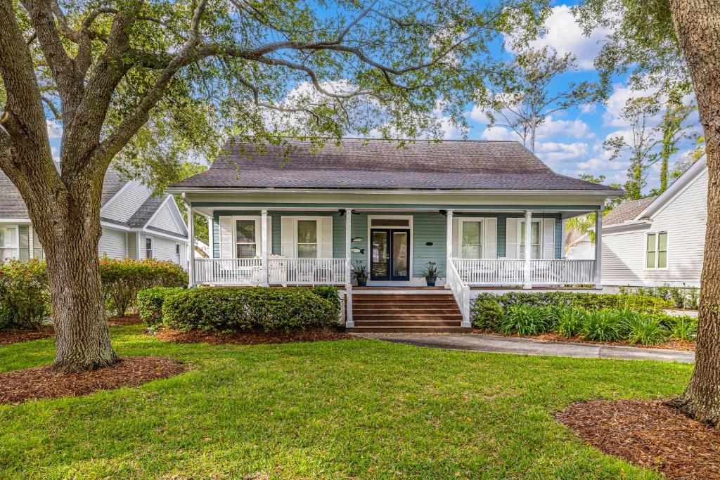 ein weißes Haus mit einer Veranda und einem Baum in der Unterkunft Carolyns by the Sea in Saint Simons Island