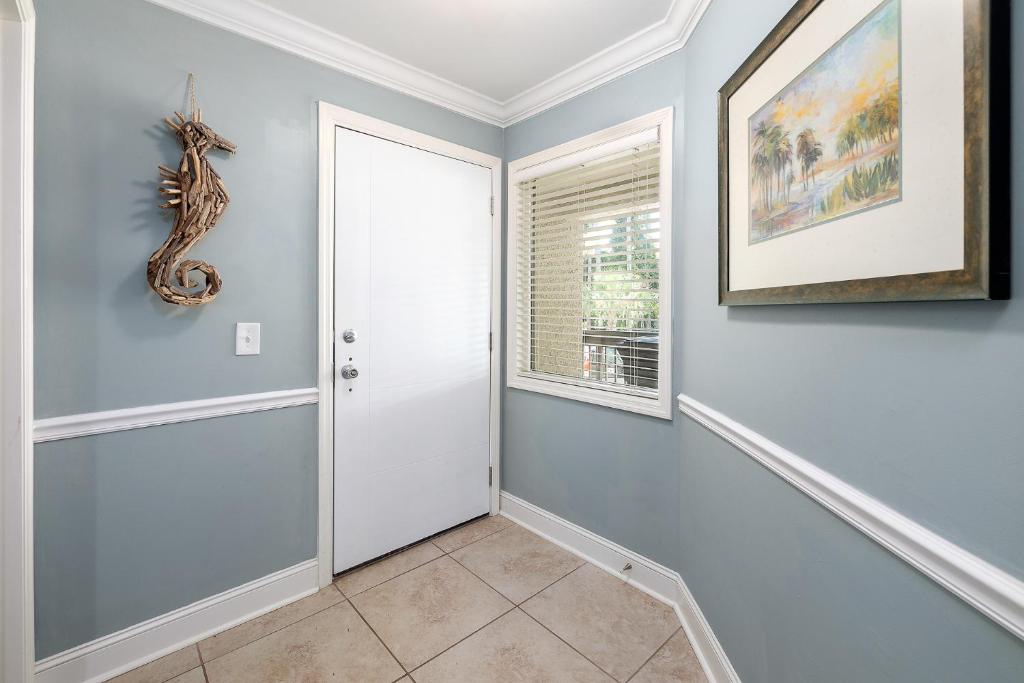 a hallway with a white door and a window at Birds Eye View in Saint Simons Island
