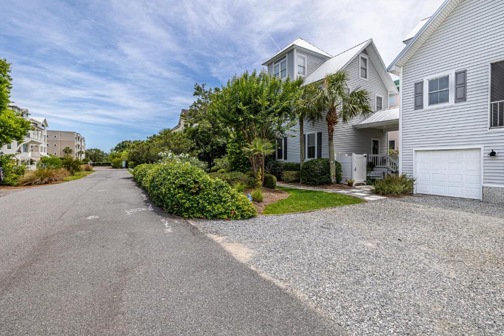 an empty street in front of a white house at 221 Olive Way in Saint Simons Island
