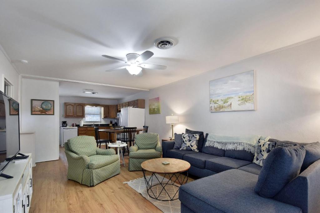 uma sala de estar com um sofá azul e cadeiras em 1058 Sherman Ave em Saint Simons Island