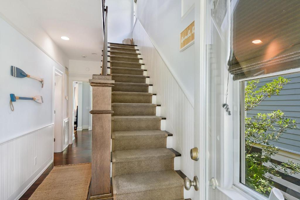 una scala in una casa con pareti bianche e pavimenti in legno di Catherine Cottage a East End