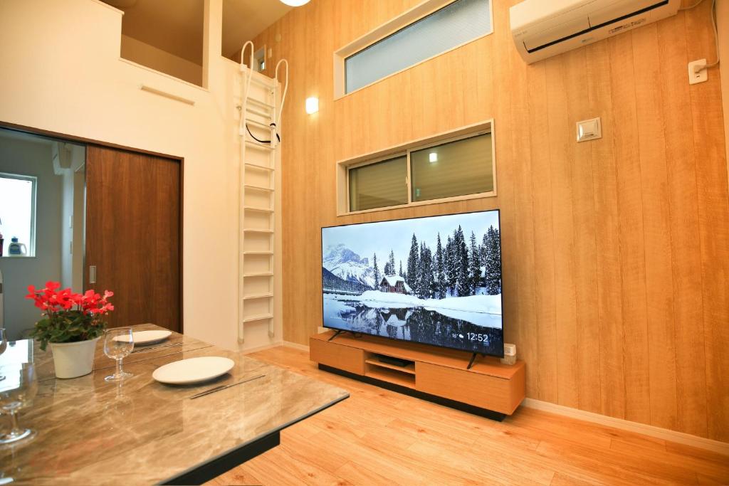 a living room with a flat screen tv on a wall at kameido k hotel in Tokyo