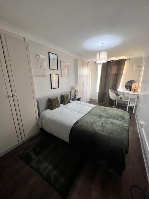 a bedroom with a bed and a chair in it at Dalston 1 bedroom flat in London