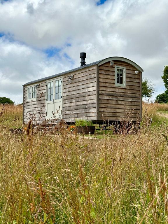 特鲁罗Private and peaceful stay in a Luxury Shepherds Hut near Truro的一座高大的草地上的老房子