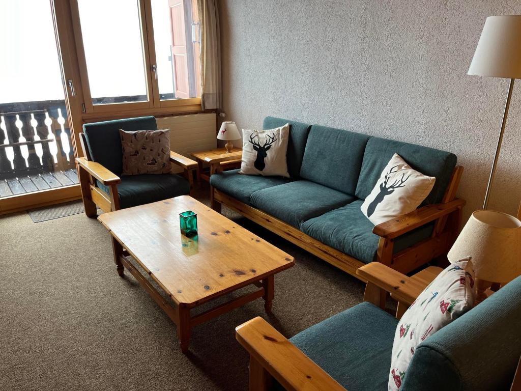 uma sala de estar com um sofá e uma mesa em Fougère 11 em Champoussin
