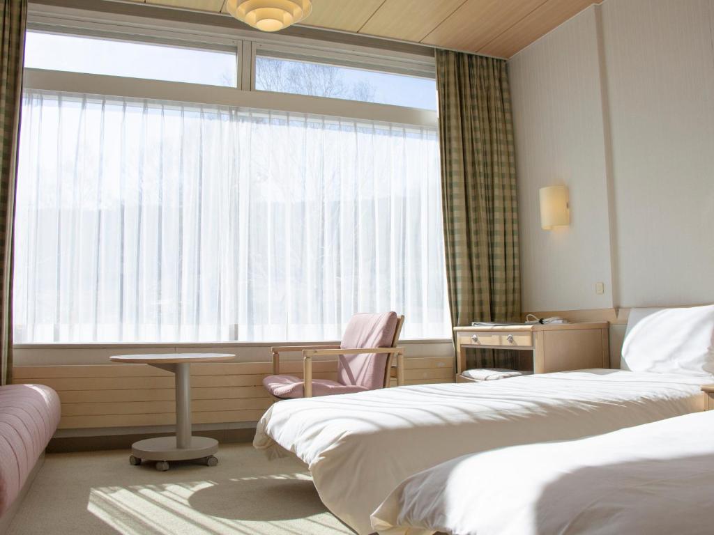 Postel nebo postele na pokoji v ubytování Shigakogen Prince Hotel