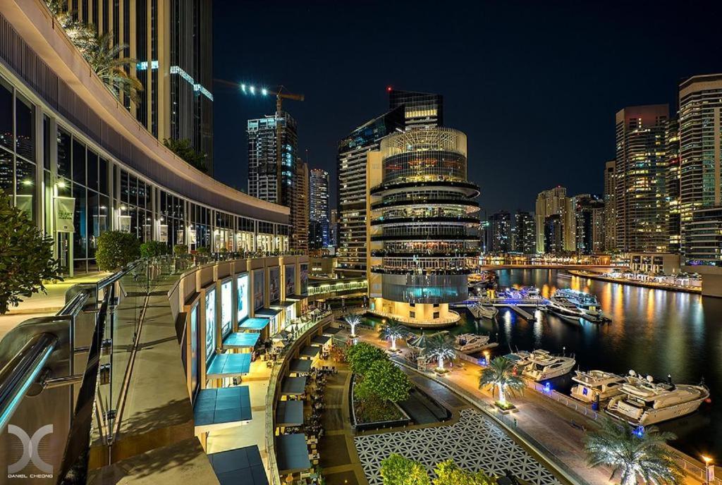 a city skyline at night with a river and buildings at luxury one bed room Apartment in dubai marina pinnacle tower in Dubai