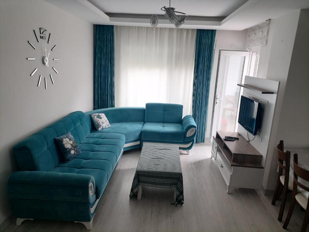 een woonkamer met een blauwe bank en een tv bij Marina 1 in Antalya