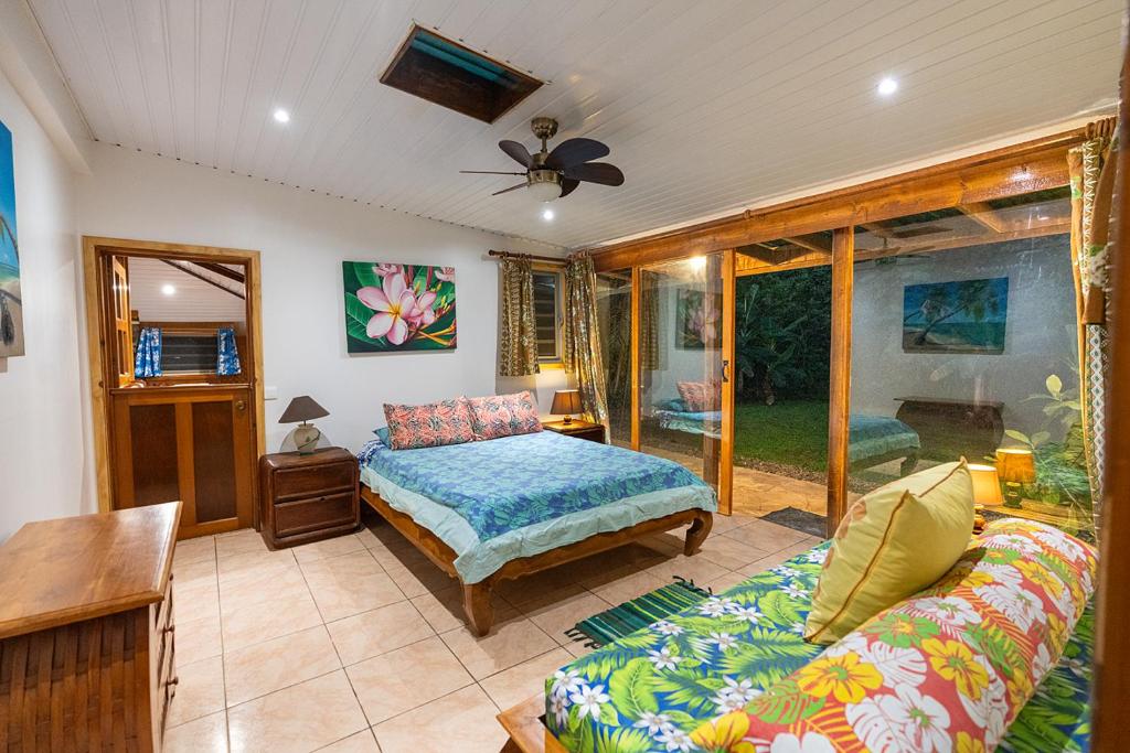 a living room with a bed and a couch at Heimanarii,slodge Tiare in Haapiti